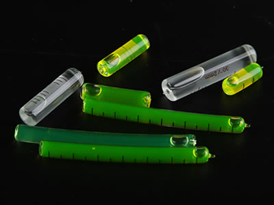 Several glass tubular bubble levels in straight or arc shape, white, green or yellow liquid colors.